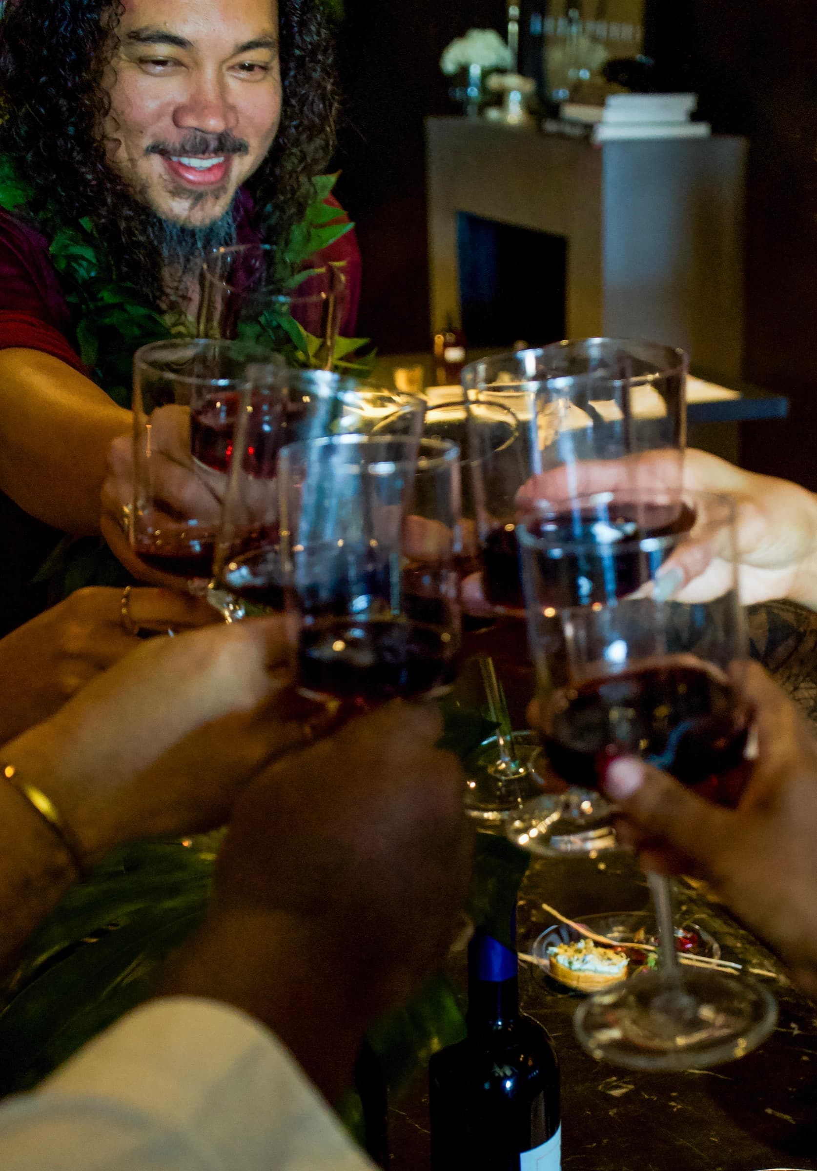 Friends raising glasses of Kekoa Reserve wine, Koa Kekoa smiling behind them